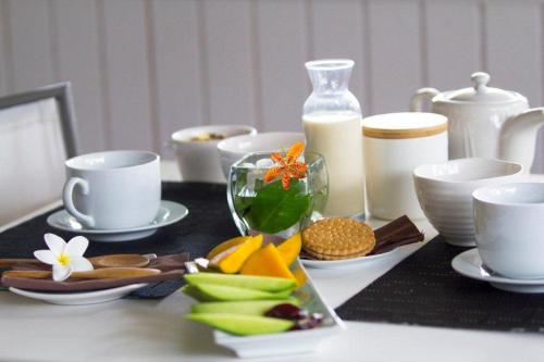a table with cups and plates of food on it at Hotel Boutique La Perouse in Hanga Roa