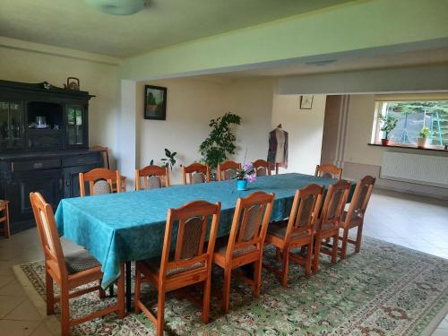 uma sala de jantar com uma mesa azul e cadeiras em Powroźnik 94 em Muszyna