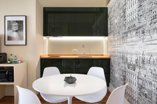 een witte eetkamer met een witte tafel en stoelen bij Historic apartment at Cardosas with balcony in Porto