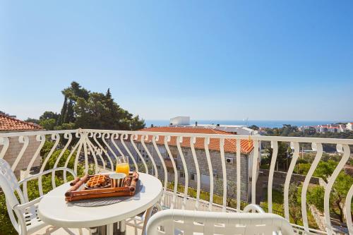 a table with a tray of food on a balcony at Villa Kate Dadić in Dubrovnik