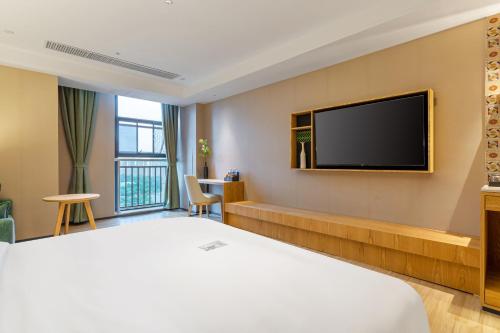 a hotel room with a bed and a flat screen tv at TRUE Go hotel in Chengdu