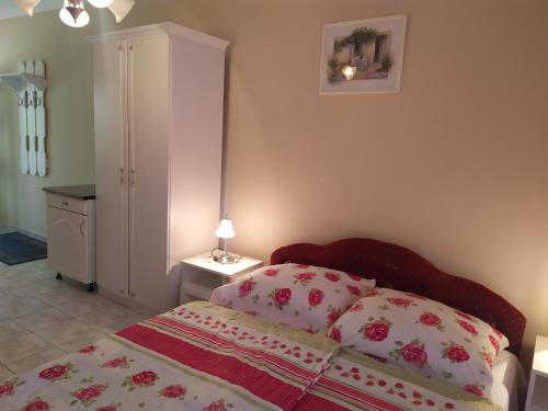 ザラカロシュにあるIldiko Appertementsのベッドルーム1室(枕2つ、キャビネット付)