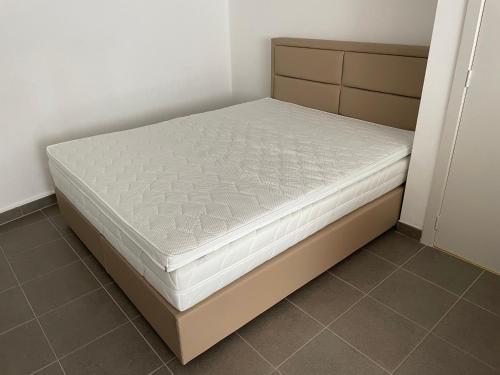 a bed in a room with a white mattress at Studio met groot zonneterras centrum Oostende in Ostend