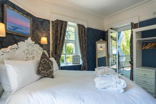 Un dormitorio con una cama blanca con toallas. en Foyers Bay Country House en Foyers