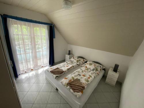 バラトンフェニヴェシュにあるEmma Villaのベッドルーム1室(ベッド2台、窓付)