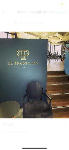 a blue wall with a chair in a room with stairs at Hôtel Restaurant du Château de la Tour in Béguey