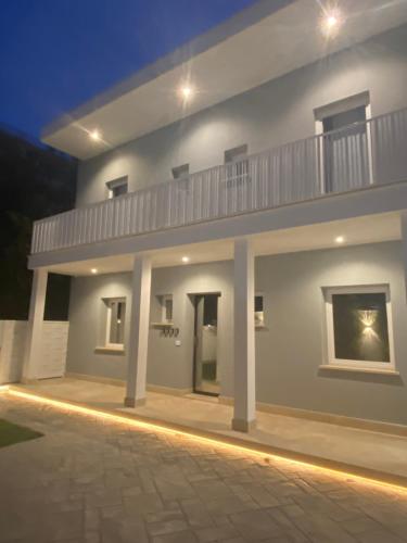 een groot wit huis 's nachts met een balkon bij Grey House Bed & Breakfast in Latina