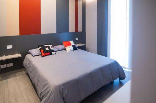 een slaapkamer met een bed met kussens erop bij Grey House Bed & Breakfast in Latina