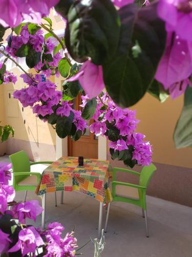 a table and chairs with purple flowers at Apartman Mi in Nerezine