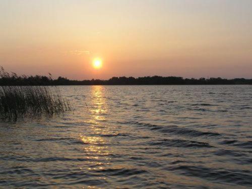 a sunset over a large body of water at Dom nad jeziorem - Mazury in Rańsk