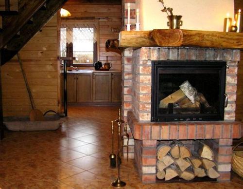 a living room with a brick fireplace in a house at Dom nad jeziorem - Mazury in Rańsk
