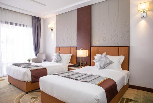 a hotel room with two beds and a window at Waves Aqua Resort in Kenitra