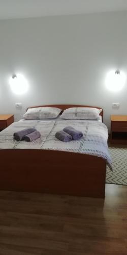 奧托查茨的住宿－Apartman Luce，一间卧室配有一张带紫色枕头的床