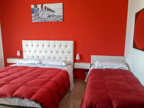 a red room with two beds with red walls at BIKE HOUSE "evo" in Seriate
