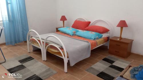 a bedroom with a bed with blue and red pillows at trivanio semplice in Sassari