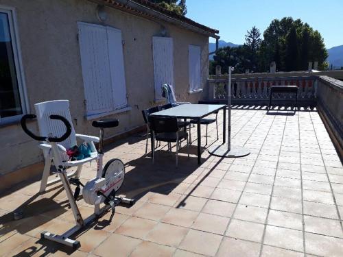 eine Terrasse mit einem Tisch und Stühlen auf einer Terrasse in der Unterkunft la provence 17 les horizons clairs chemin des passons in Aubagne