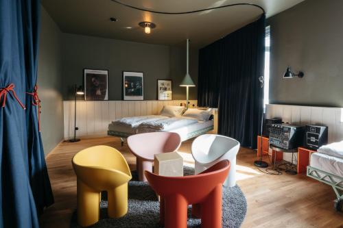 a bedroom with colorful chairs and a bed at Superbude Wien Prater in Vienna