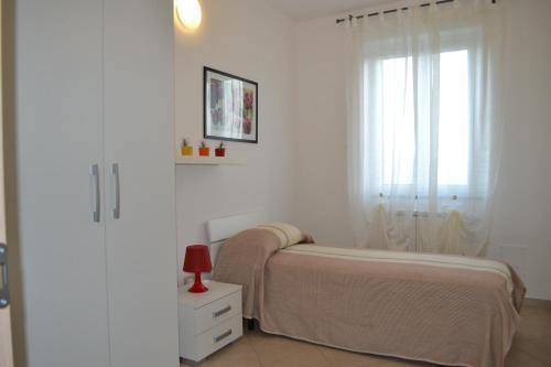 ein weißes Schlafzimmer mit einem Bett und einem Fenster in der Unterkunft Casa di Gian in Arnasco