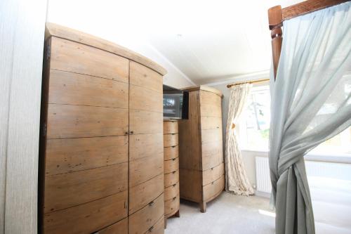 1 dormitorio con puerta de madera y cortinas en Hollicarrs - Kingfisher Lodge, en York