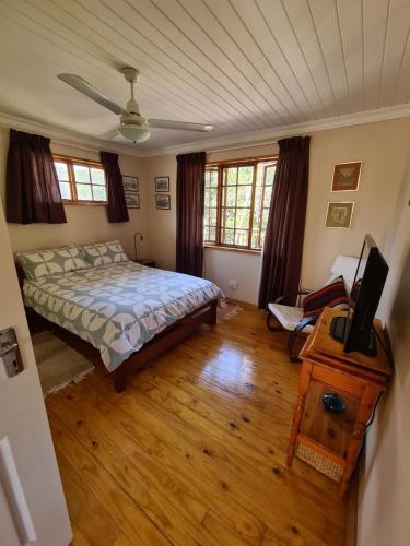 a bedroom with a bed and a television in it at Natures Cabin in Hibberdene