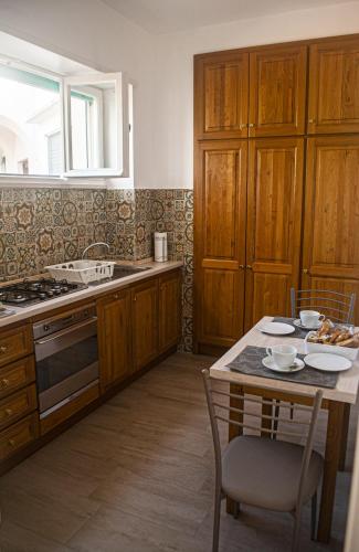 a kitchen with wooden cabinets and a table with chairs at CasaAle in Anacapri