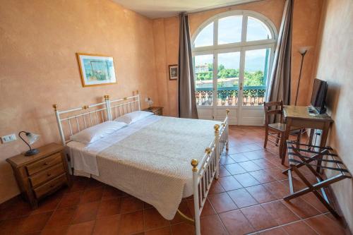 a bedroom with a bed and a large window at Albergo dell'Academia in Mondovì