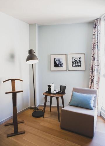 a living room with a chair and a table at Hotel Zinema7 in Donostia-San Sebastián