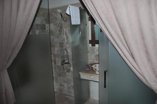 a bathroom with a shower with a glass door at Kemerli House in Avanos