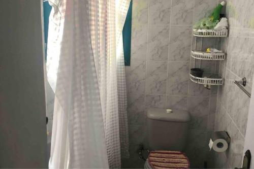 a bathroom with a white shower curtain and a toilet at Cozy Relaxed Ground Chalet with Terrace-Ras Sudr in Ras Sedr