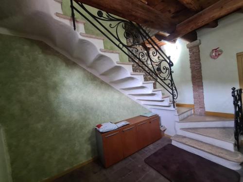 una escalera en una casa con barandilla de hierro forjado en LA TUA CASA IN VALPOLICELLA, en SantʼAmbrogio di Valpolicella