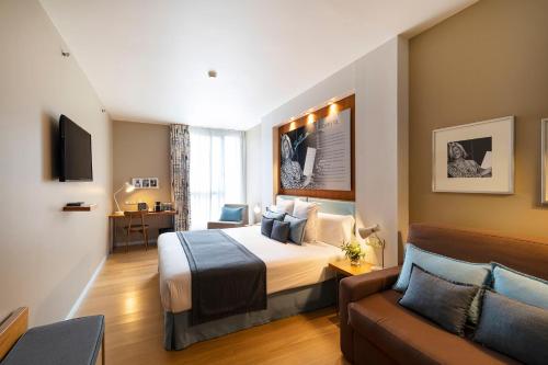 a hotel room with a bed and a couch at Hotel Zinema7 in Donostia-San Sebastián