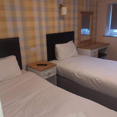 um quarto de hotel com duas camas e um espelho em The Station Inn em Birmingham