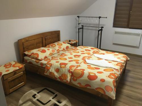 a bedroom with a bed with an orange patterned blanket at Casa Bambi in Sovata