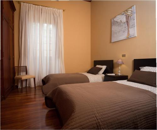 a hotel room with two beds and a window at Casa Emblemática Los Oliva in Gáldar