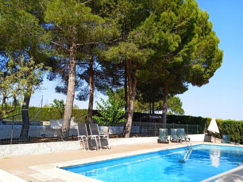 una piscina con césped y árboles en Hotel El Zorro, en Barranda