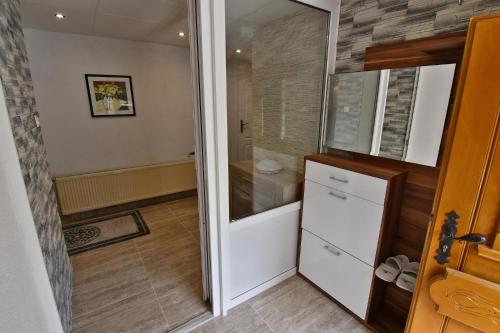 a small bathroom with a refrigerator and a shower at APARTMENTS V+K in Tatranska Strba
