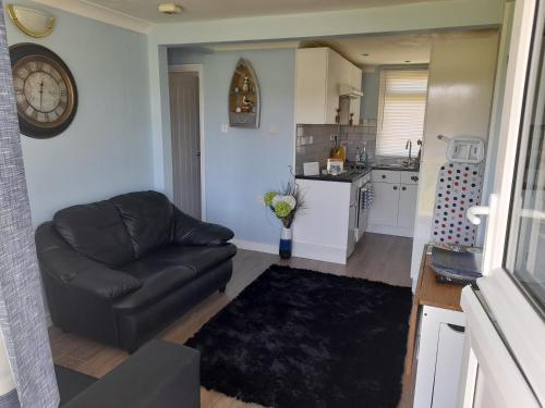 a living room with a couch and a kitchen at Sunrise 77 Sandown Bay Holiday Centre Generous Ferry Saving! in Sandown