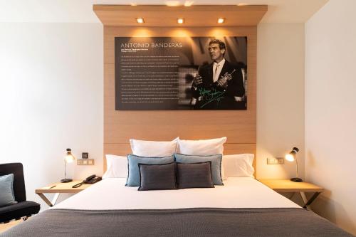 a bedroom with a bed with a poster on the wall at Hotel Zinema7 in Donostia-San Sebastián