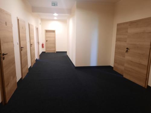 a hallway of an office with doors and a carpet at Hostel Grębocin in Grębocin