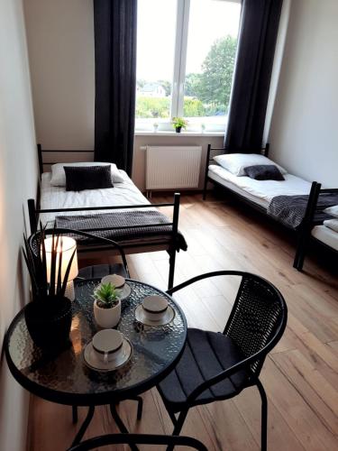 a living room with two beds and a table and chairs at Hostel Grębocin in Grębocin