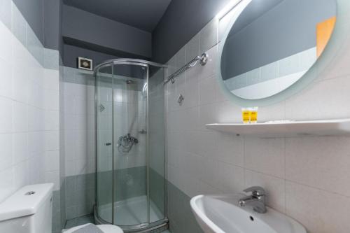 y baño con ducha, aseo y lavamanos. en Stalis Hotel, en Atenas