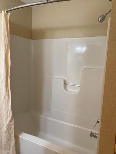 a bathroom with a white tub and a shower at Wayne Motel in Fort Wayne