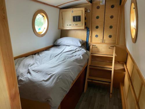 Habitación pequeña con cama y ventana en Smoke (Rowington Narrowboats), en Warwick