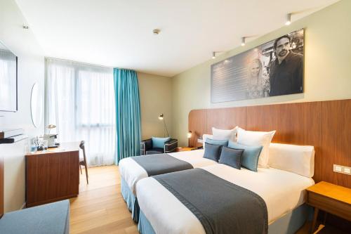 a hotel room with a large bed and a desk at Hotel Zinema7 in Donostia-San Sebastián