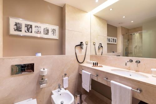 a bathroom with a sink and a toilet and a mirror at Hotel Zinema7 in Donostia-San Sebastián