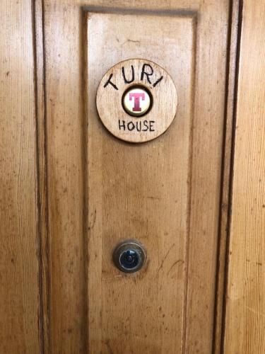 a wooden door with a house sign on it at House Turi in Ardea