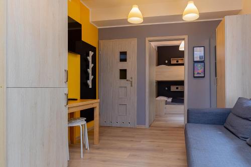 a living room with a couch and a bedroom at Hostel Szczelinka in Pasterka
