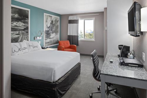 a hotel room with a bed and a desk at Home Inn Medicine Hat in Medicine Hat