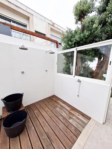 a wooden deck with a large window on a building at Cloud to Chill Surfhouse Baleal in Ferrel