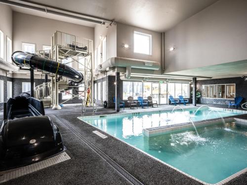 a swimming pool with a slide in a building at Home Inn & Suites Saskatoon South in Saskatoon